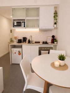 a kitchen with a table and white cabinets at Dolce Apartment in Buenos Aires
