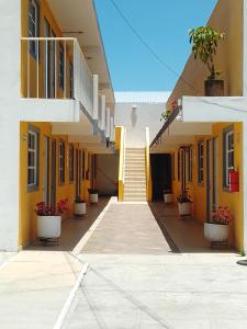a courtyard of a building with yellow walls and potted plants at Posada del Ángel in Pachuca de Soto