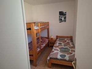 a small room with two bunk beds and a bed at Gîtes proche lac de chalain in Montigny-sur-lʼAin