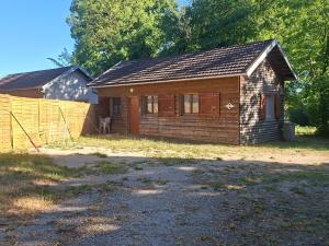 a small wooden house with a fence in front of it at Gîtes proche lac de chalain in Montigny-sur-lʼAin