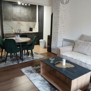 a living room with a couch and a table at Apartman Montis in Kupres