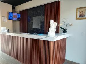 a lobby with a counter with a statue on it at Posada del Ángel in Pachuca de Soto