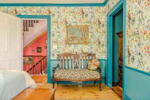 a bedroom with a chair and colorful wallpaper at Gould Swaby Mansion in Seneca Falls