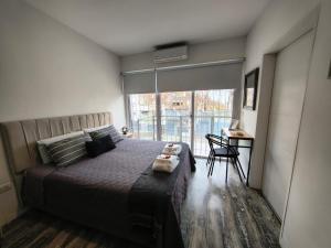 a bedroom with a bed and a desk and a window at @juanbjustoapartamento in Buenos Aires