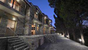 a stone building with stairs on a street at night at Platres Villas in Kato Platres