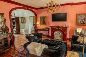 a living room with a couch and a fireplace at Gould Swaby Mansion in Seneca Falls
