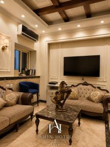 a living room with a couch and a flat screen tv at Amin Hotel Cairo Downtown in Cairo