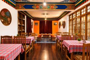a restaurant with tables and chairs in a room at Zotpa Hostel in Leh