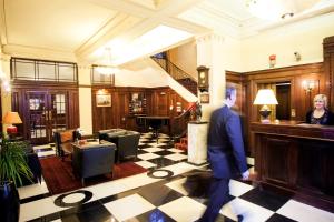 a man in a suit walking through a lobby at Wellesley Boutique Hotel in Wellington