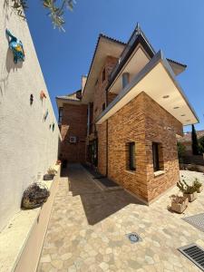 a house with a brick wall and a stone courtyard at Hostal Los Coronales in Madrid