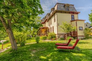 a pair of red chairs in the yard of a house at Gould Swaby Mansion in Seneca Falls