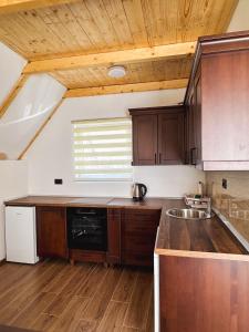 a kitchen with wooden cabinets and a wooden ceiling at Apartmani Vila Zabljak in Žabljak