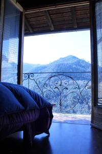 een slaapkamer met een groot raam met uitzicht op een berg bij Casa Luna in Apricale