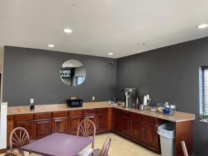 a kitchen with wooden cabinets and a table and a mirror at Days Inn by Wyndham Topeka in Topeka