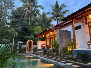 a house with a swimming pool in front of it at AVYANA sanctuary in Gobleg