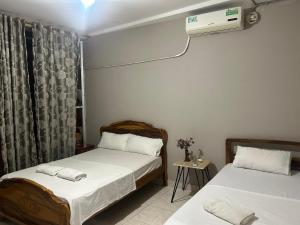 a bedroom with two beds and a air conditioner at Residencial Turístico Rio Guayas in Guayaquil