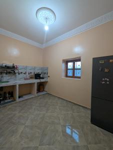 an empty room with a counter and a refrigerator at Sahara Desert Apartment with Camel Tours & Free WiFi in Merzouga +22 photos