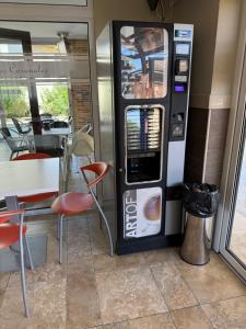 a drink vending machine next to a table and a table and chair at Hostal Los Coronales in Madrid