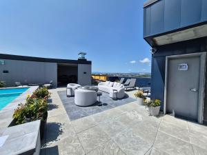 a patio with white chairs and a pool on a building at Suites Cobalt in Quebec City