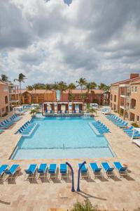 uma grande piscina com espreguiçadeiras azuis em Divi Dutch Village Beach Resort em Palm-Eagle Beach
