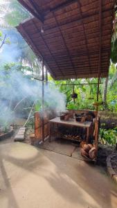 an outdoor grill with smoke coming out of it at Homestay Nam Hàm Luông in Ben Tre