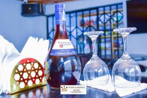 a bottle of wine sitting next to two wine glasses at Posh lounge gardens in Gatimu