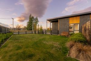 a backyard of a house with a grass yard at Totara Haven in Twizel