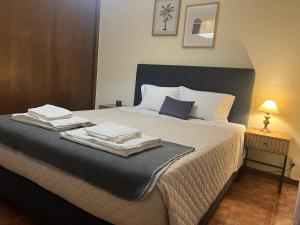 a bedroom with a bed with towels on it at Alojamento, Chelas Rural AL in Mirandela