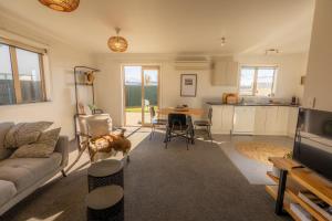 a living room with a couch and a table with a cat at Relax on Rata, Cottage 2 in Twizel +11 photos