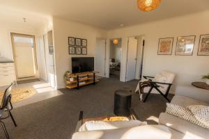 a living room with a couch and a television at Relax on Rata, Cottage 2 in Twizel