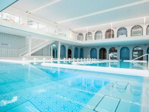 a large swimming pool in a building with water at Bel Hôtel Oléron Thalasso & Spa - MGallery Collection in Saint-Trojan-les-Bains