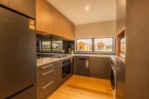 a kitchen with wooden floors and stainless steel appliances at Heavenly Hideaway, House B in Twizel