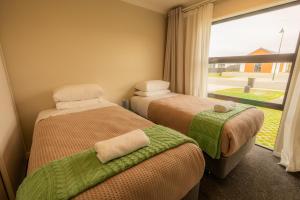 two beds in a room with a window at Heavenly Hideaway, House B in Twizel