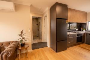a living room with a couch and a kitchen at Heavenly Hideaway, House B in Twizel +6 photos