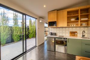a kitchen with a large sliding glass door leading to a deck at Ben Ohau Views The Studio in Twizel
