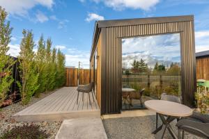a garden room with a wooden deck and a table at Ben Ohau Views The Studio in Twizel +9 photos