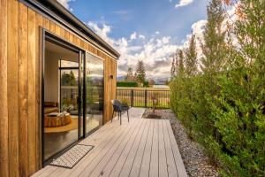 a wooden deck with a chair on a house at Ben Ohau Views The Studio in Twizel