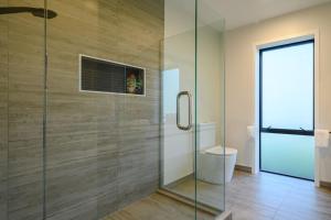 a bathroom with a glass shower with a toilet at 31 on Boundary in Twizel +28 photos