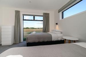 a bedroom with two beds and a large window at 31 on Boundary in Twizel