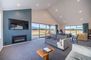 a living room with a couch and a fireplace at 31 on Boundary in Twizel