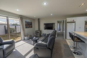 a large living room with couches and a television at Irishman Drive Escape in Twizel