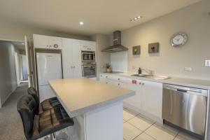 a kitchen with white cabinets and a counter top at Irishman Drive Escape in Twizel