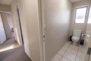 a bathroom with a toilet and a window at Irishman Drive Escape in Twizel +11 photos