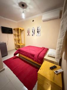 a bedroom with a red bed and a red rug at Lighthouse Inn Dahab in Dahab