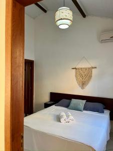 a bedroom with a bed with two slippers on it at D'Ajuda Inn in Arraial d'Ajuda