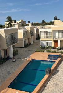 a swimming pool in front of some apartment buildings at NobleStaysTz in Dar es Salaam