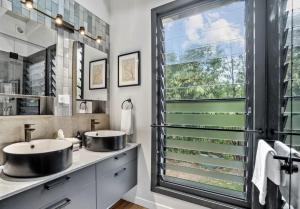 a bathroom with two sinks and a large window at Creekside Cottage, pet friendly w pool in Perwillowen
