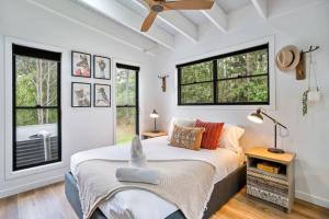 a bedroom with a bed and two windows at Creekside Cottage, pet friendly w pool in Perwillowen +28 photos