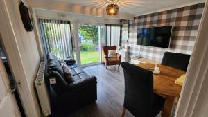 a living room with a couch and a table at Ranger - Snowdon Cabins holiday let Caernarfon in Caeathro