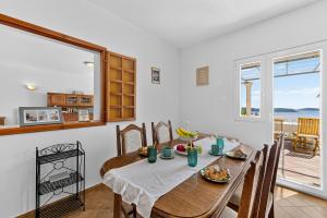 a dining room with a table and a view of the ocean at Room Blue View in Mlini
